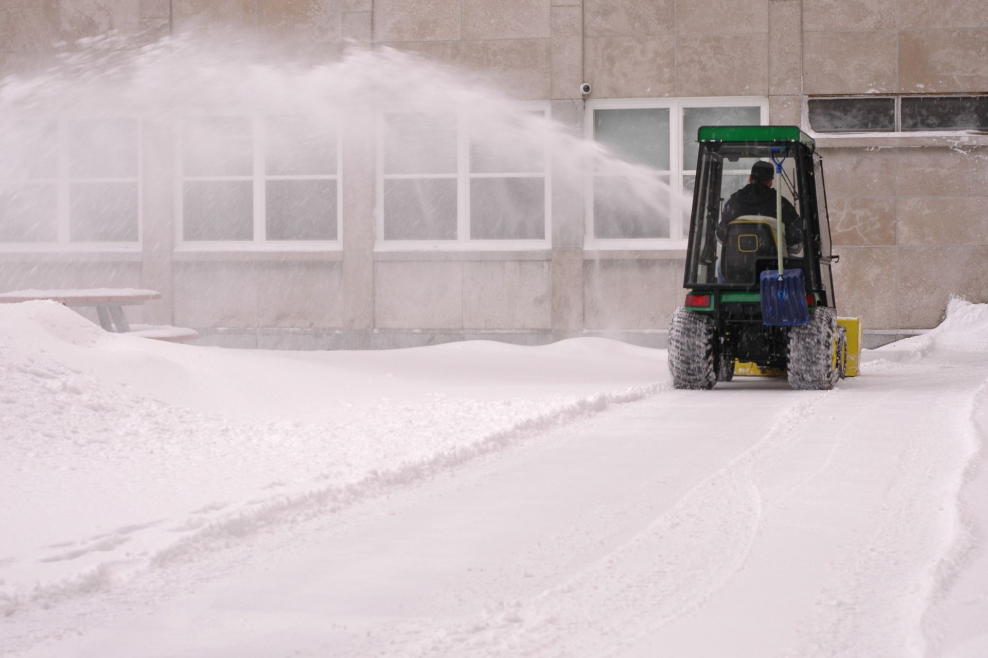 a man driving a heavy duty snow blower